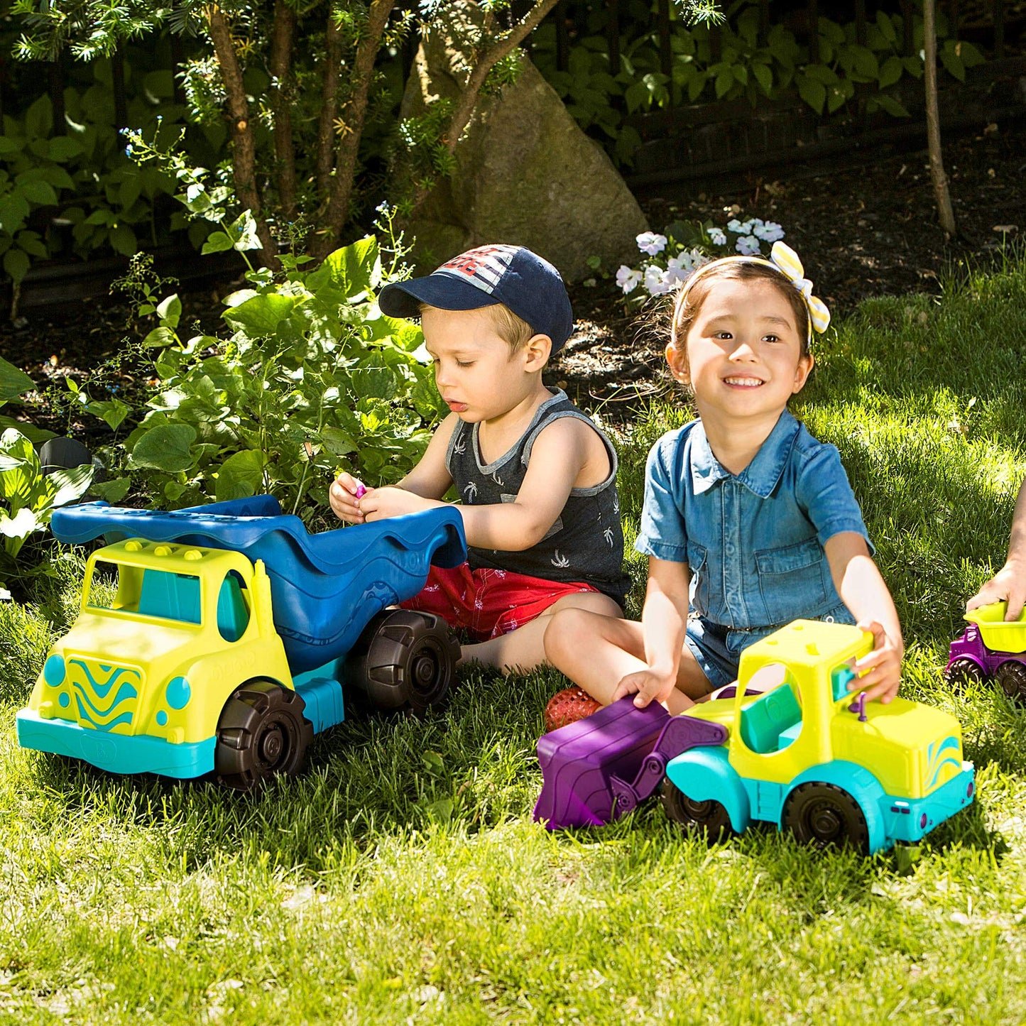 Children playing with large toy trucks outdoors